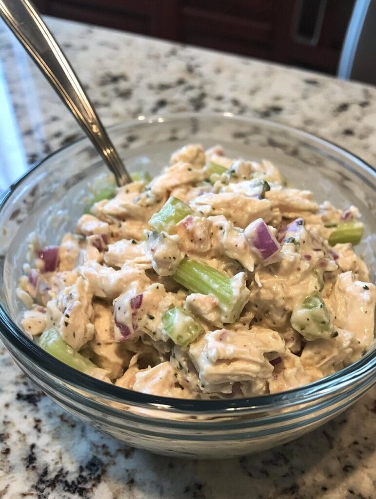 Chicken salad served in different ways: as a sandwich, on greens, and as an appetizer on crackers.